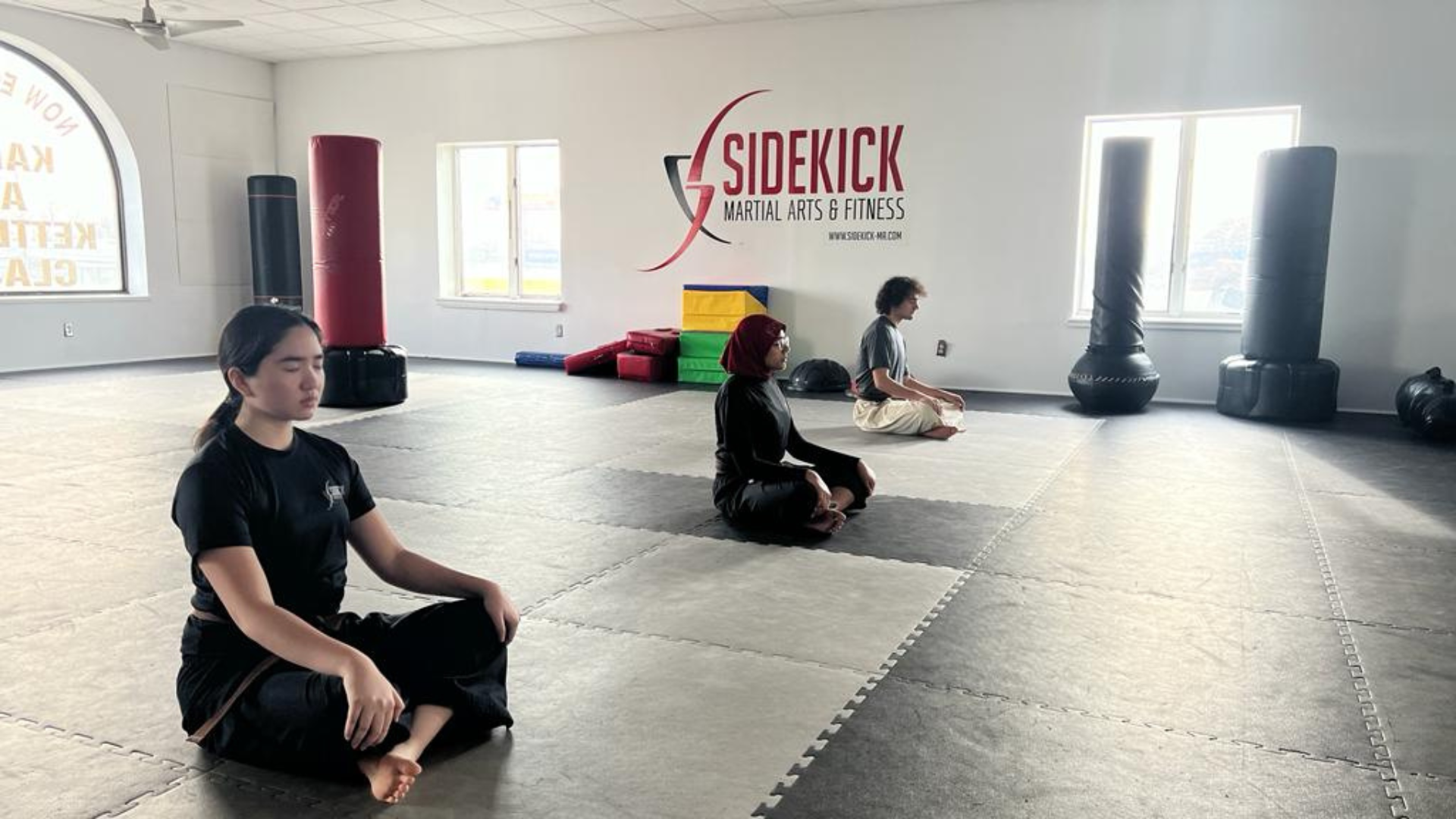 Students meditating on the Sidekick dojo floor